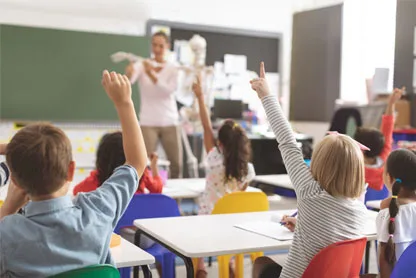 Bambini che alzano le mani in classe